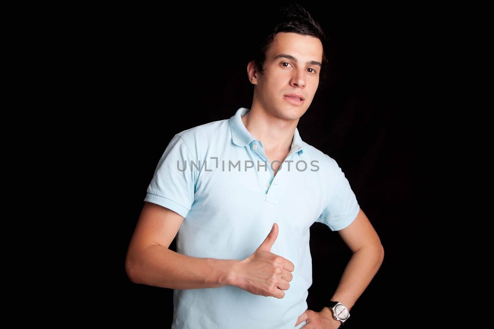 Young boy posing isolated over black background