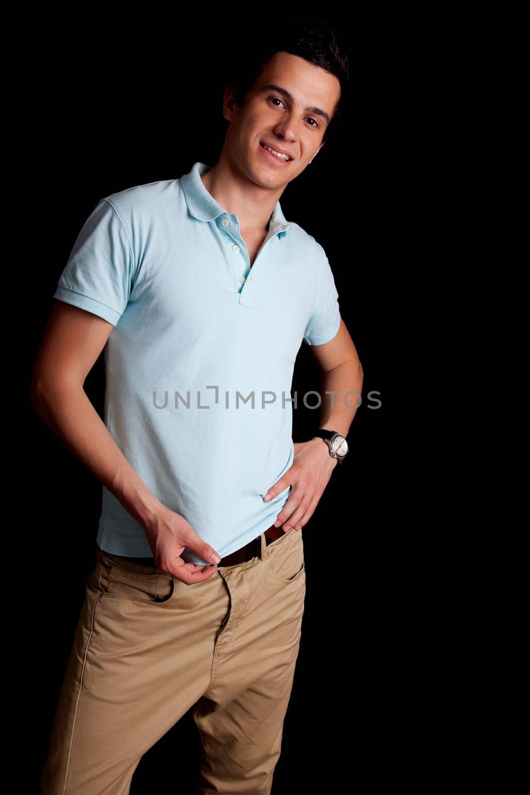 Young boy posing isolated over black background