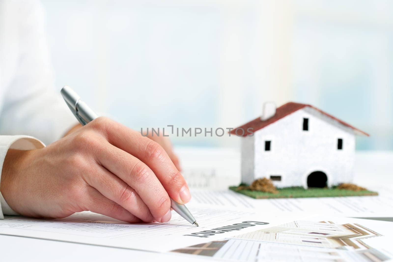 Extreme close up of female hand signing real estate contract.