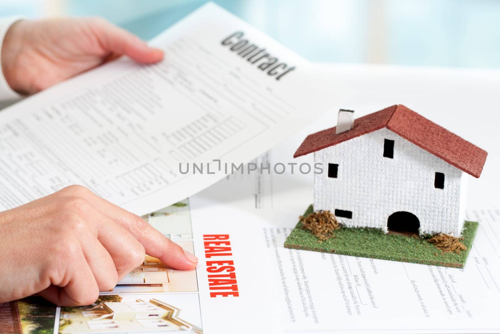 Close up of female hands reviewing real estate property documents.