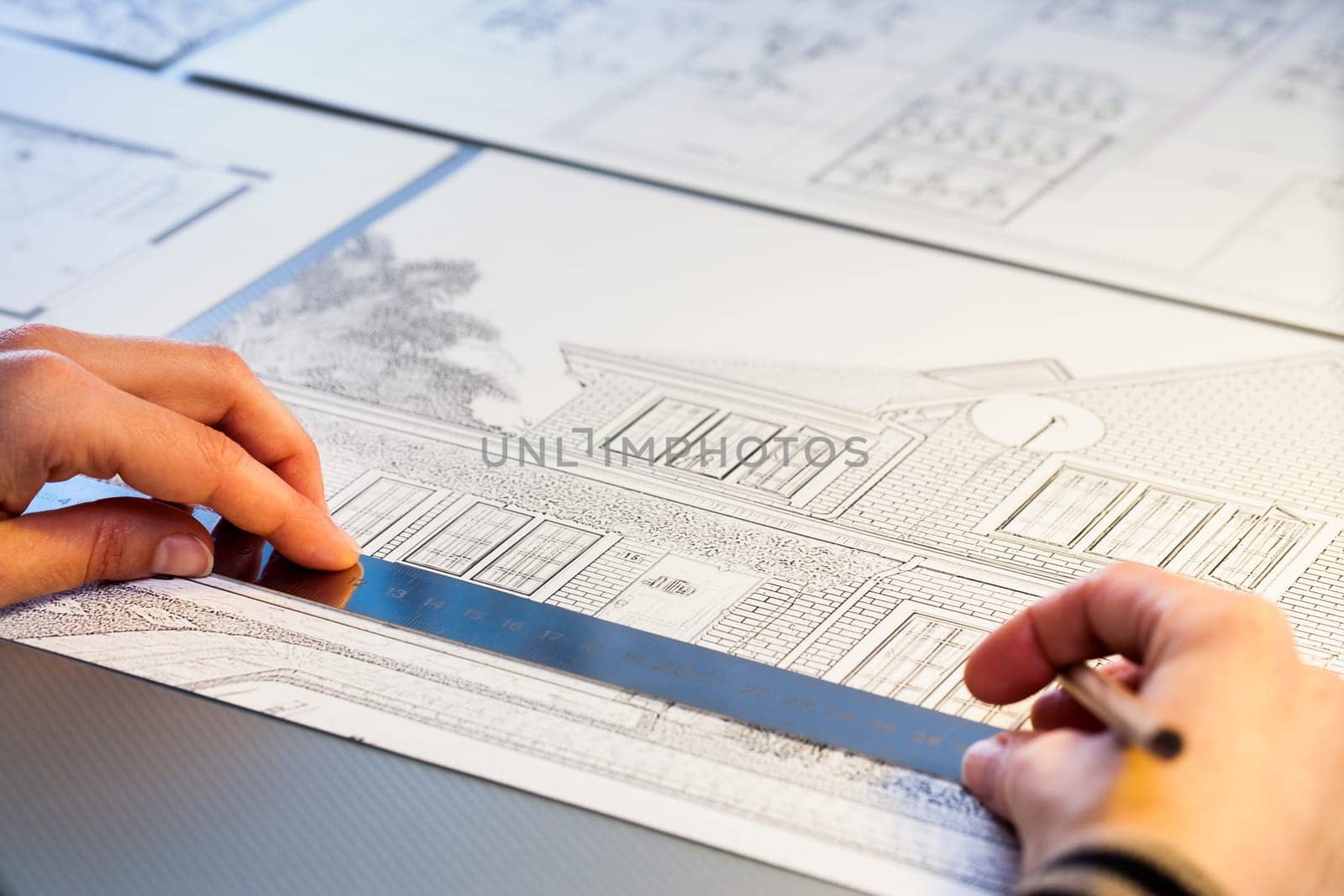 Macro close up of Hands measuring detail on house plan.