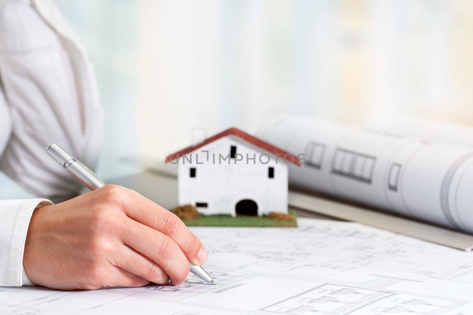 Close up of female hand working on real estate business documents.