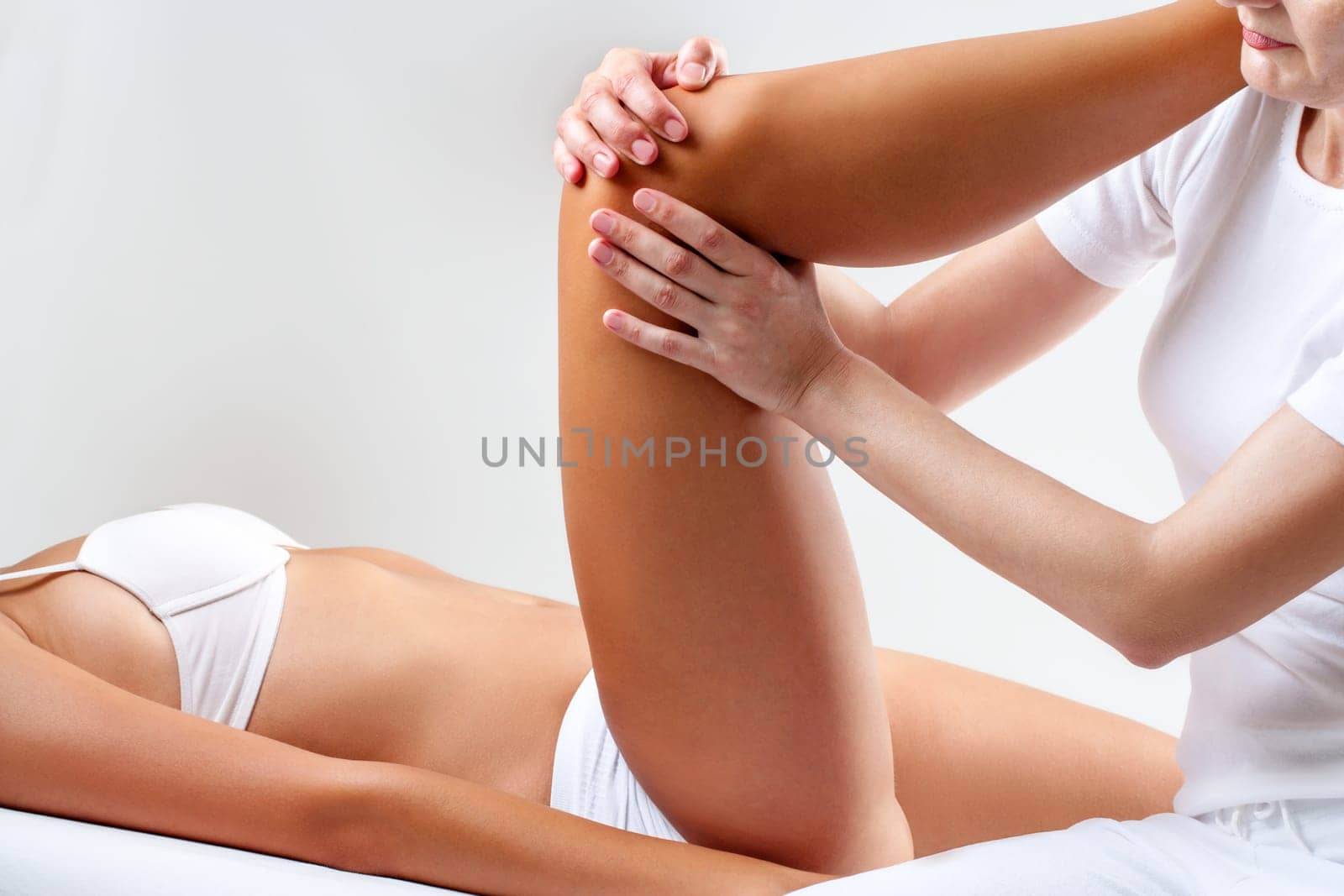 Close up of physiotherapis manipulating female knee.