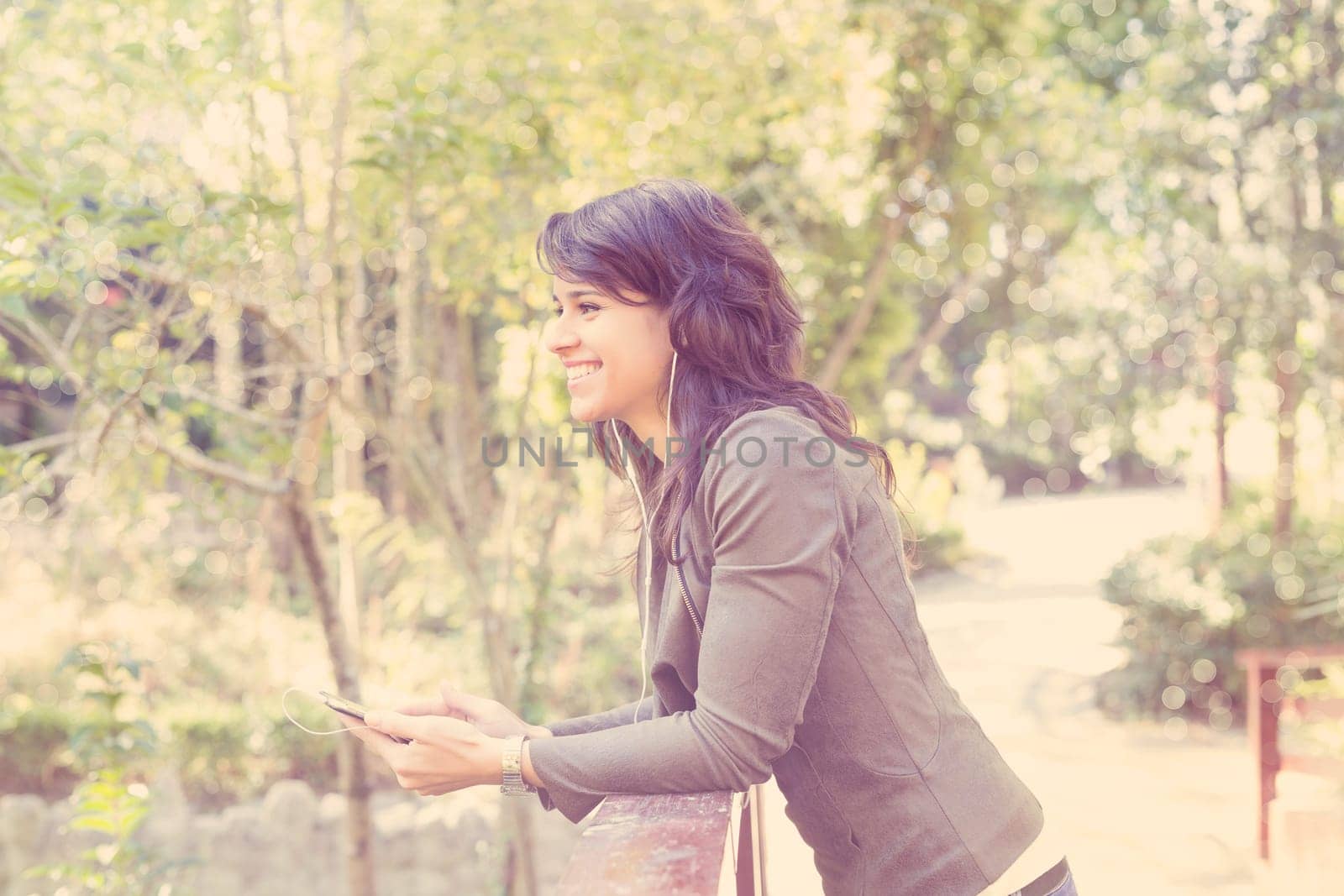 Young woman listening to music at the park