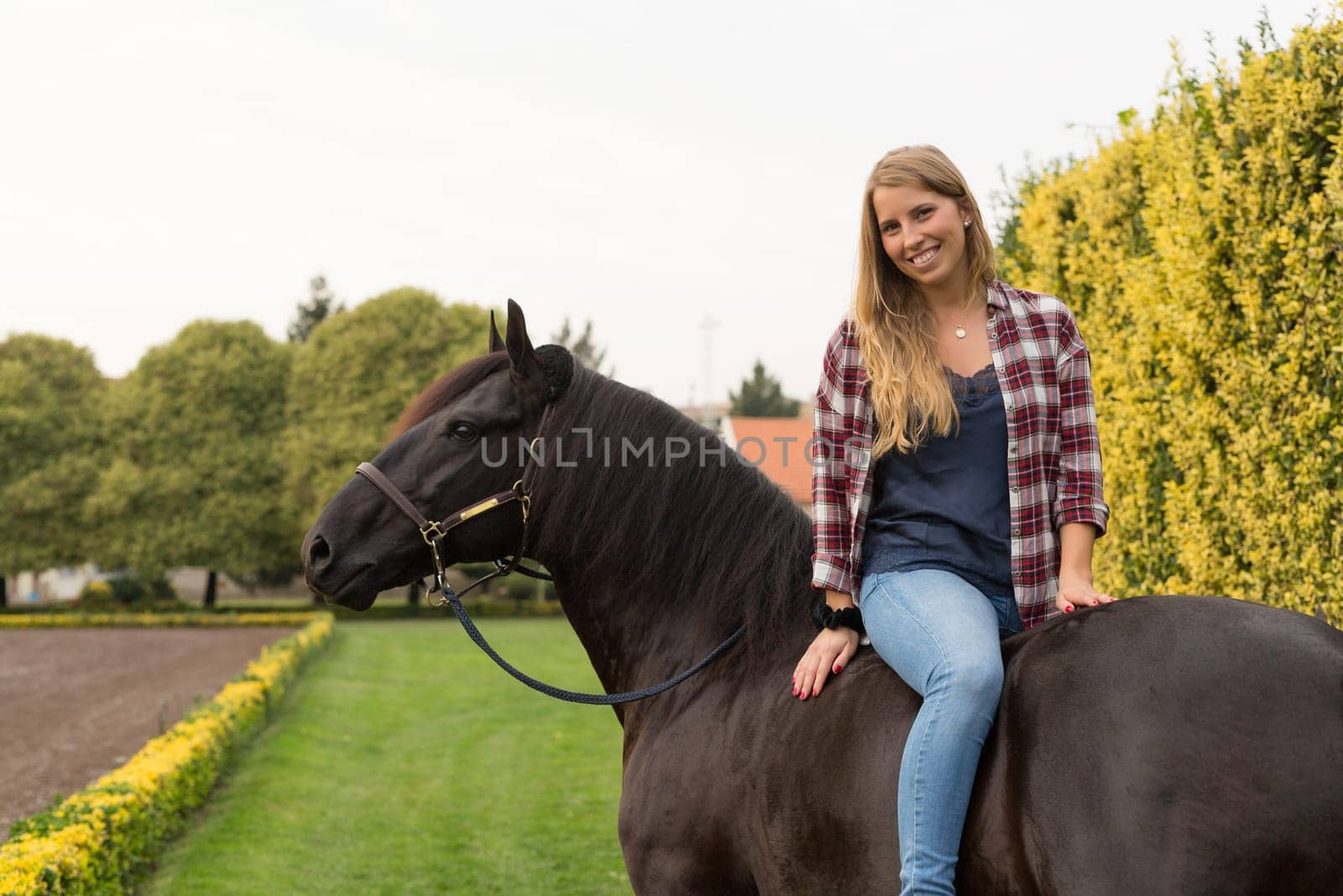 Beautiful and natural young woman spending sometime with her horse