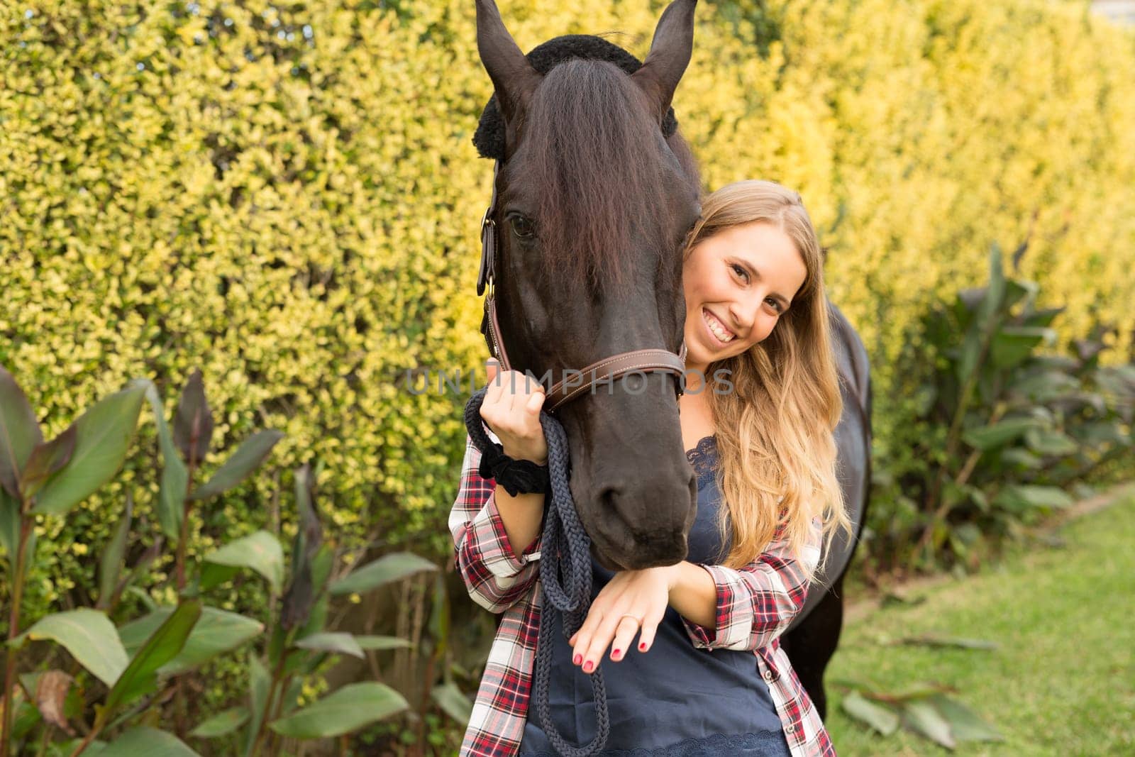 Beautiful and natural young woman spending sometime with her horse