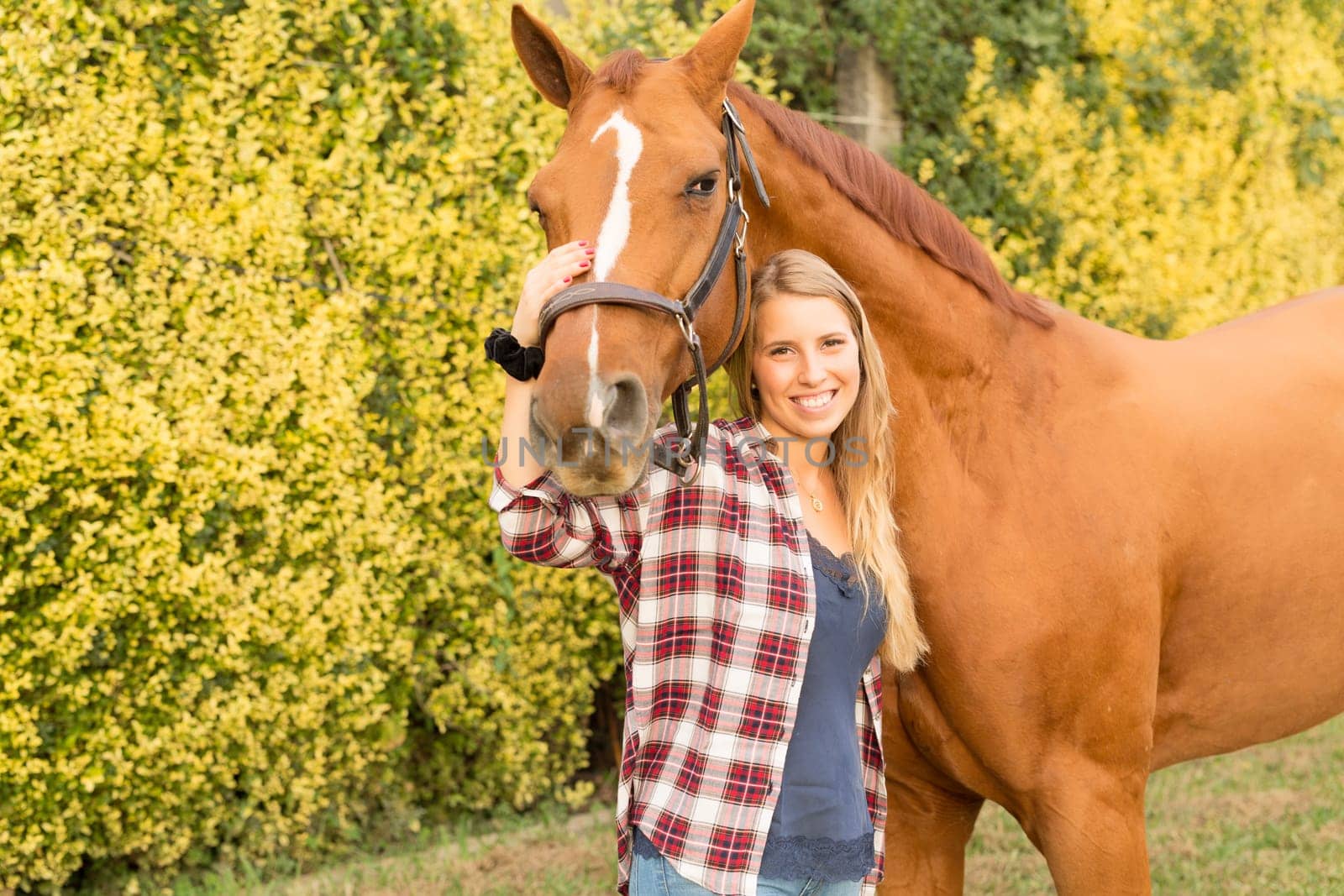 Beautiful and natural young woman spending sometime with her horse