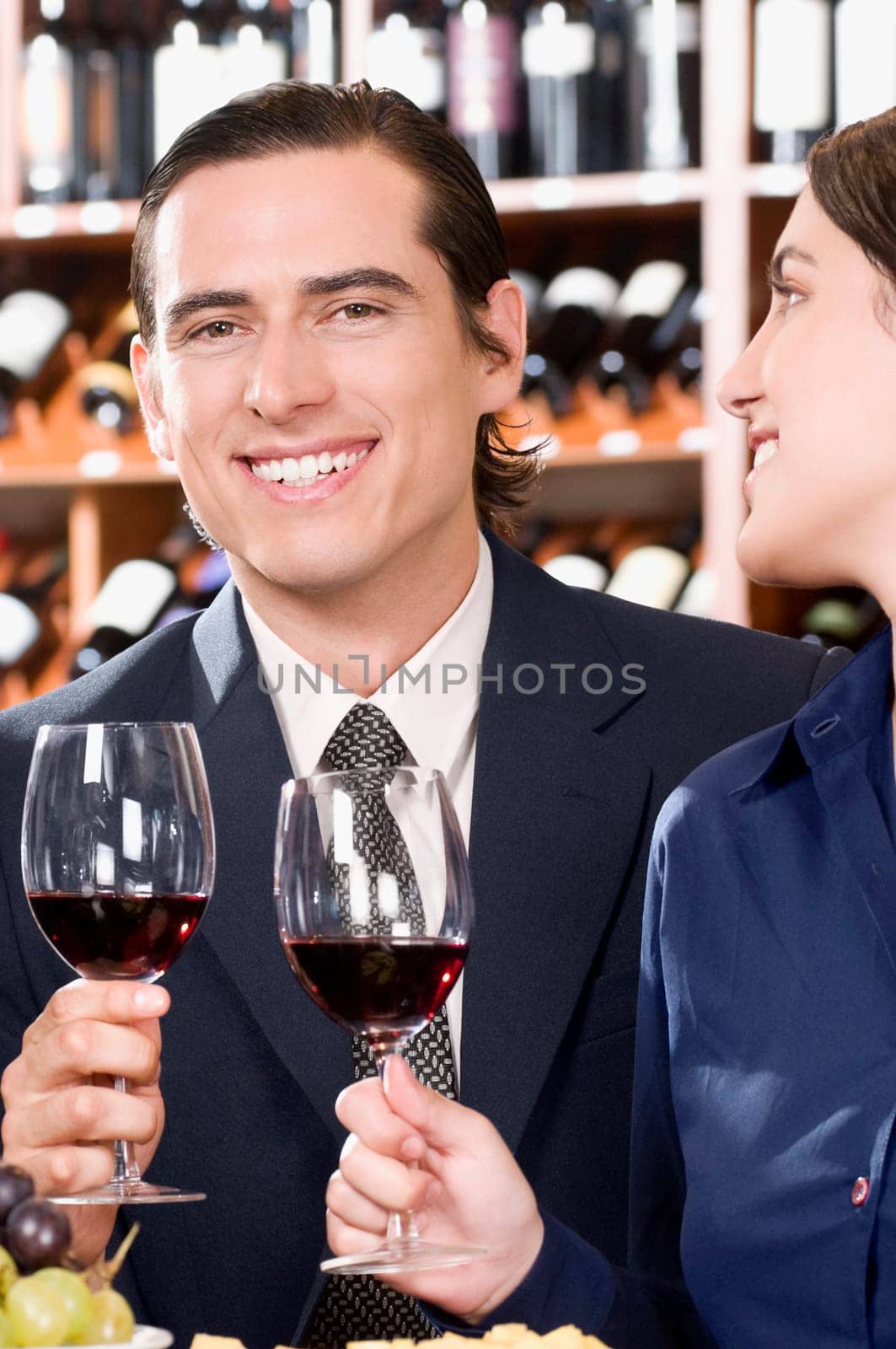 Business couple holding wine glasses and smiling