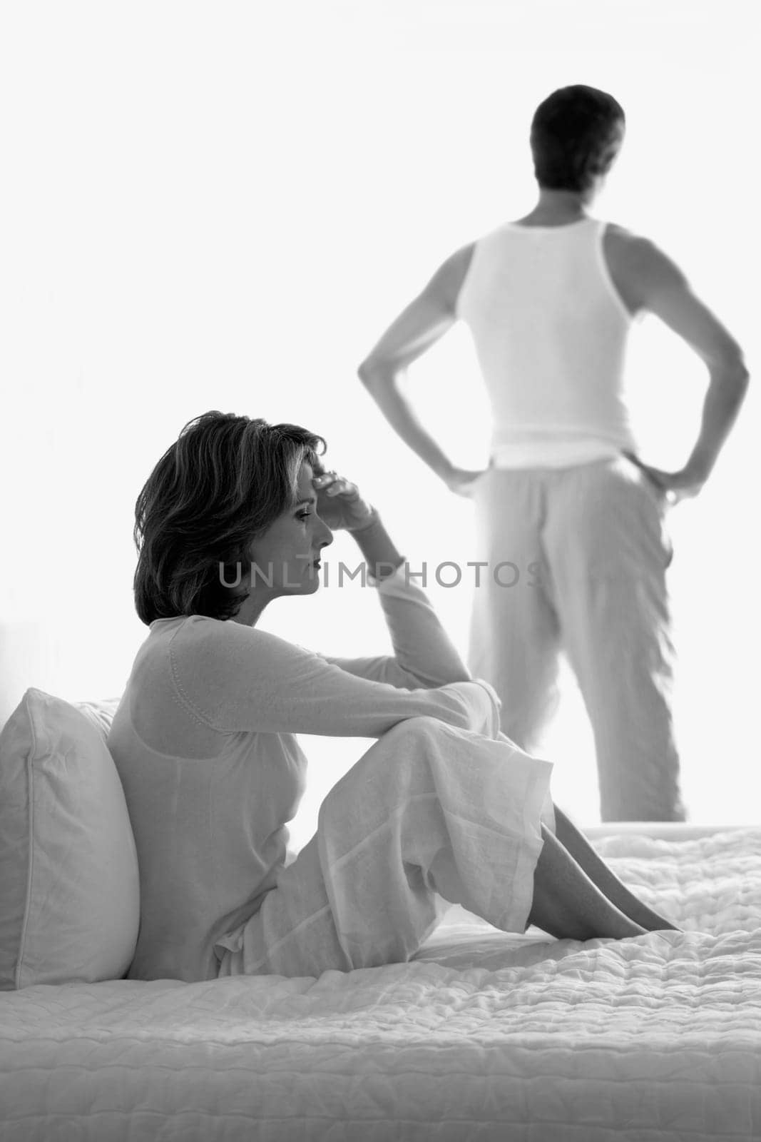 Woman looking sad with a man standing in the background