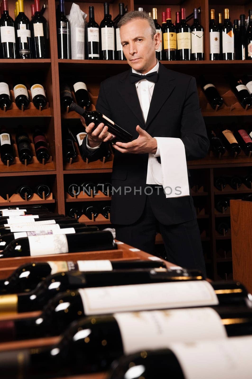 Businessman holding a wine bottle in a bar