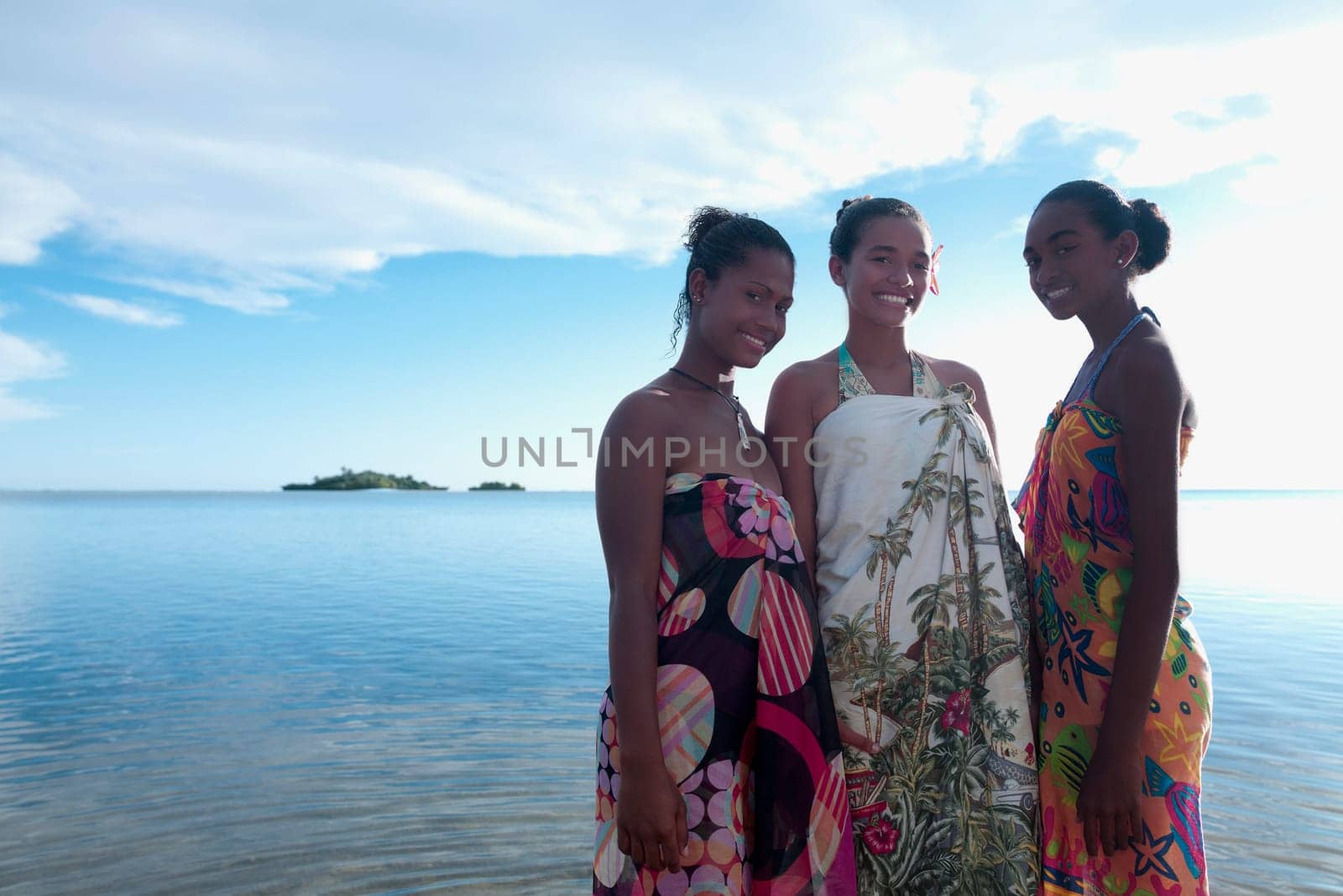 Portrait of a teenage girl with her friends smiling on the beach