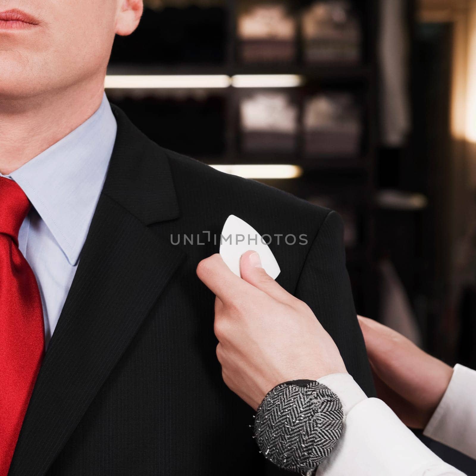Female tailor taking measurement of a businessman