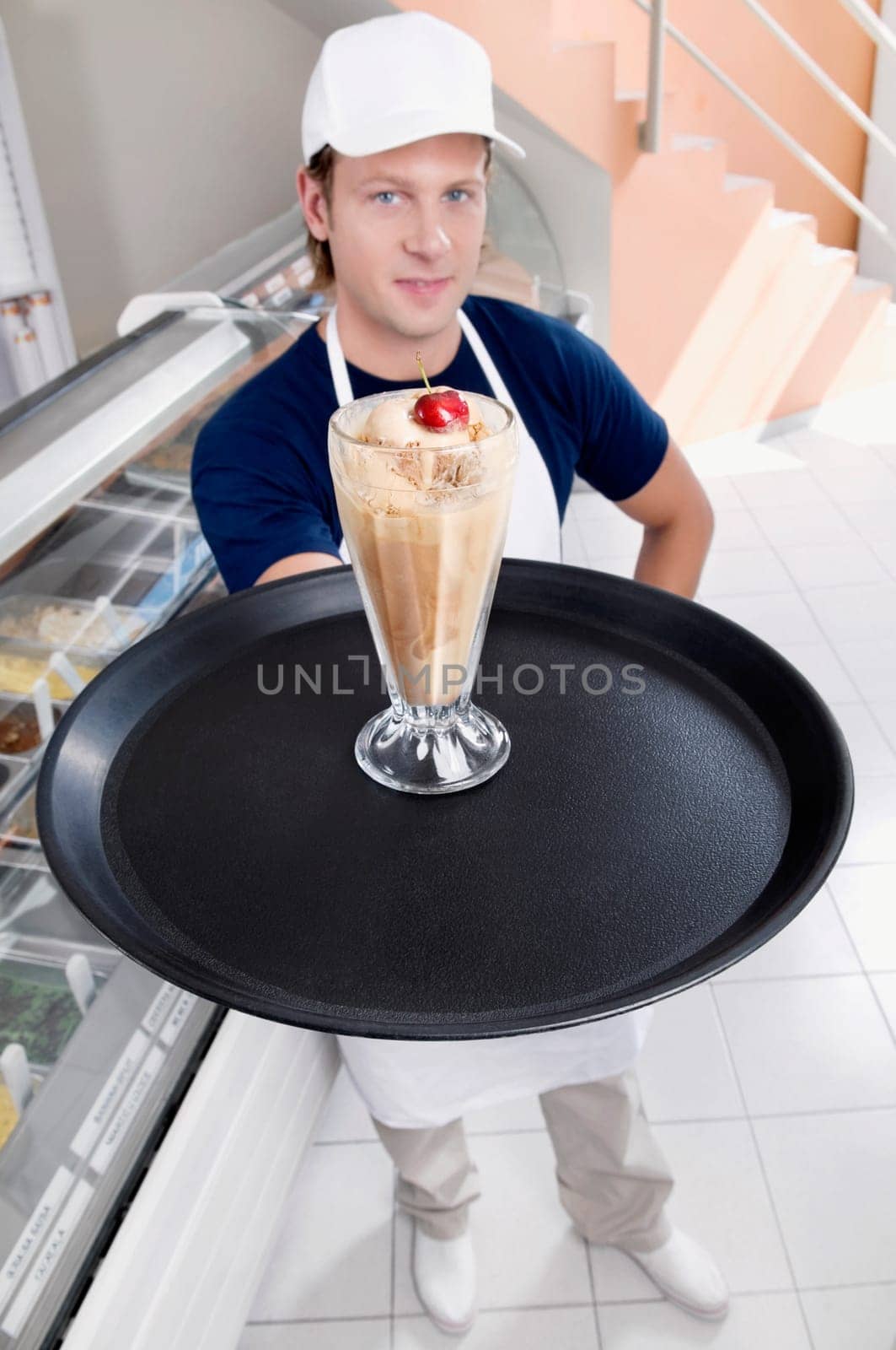 Ice cream seller holding a tray with a glass of ice cream