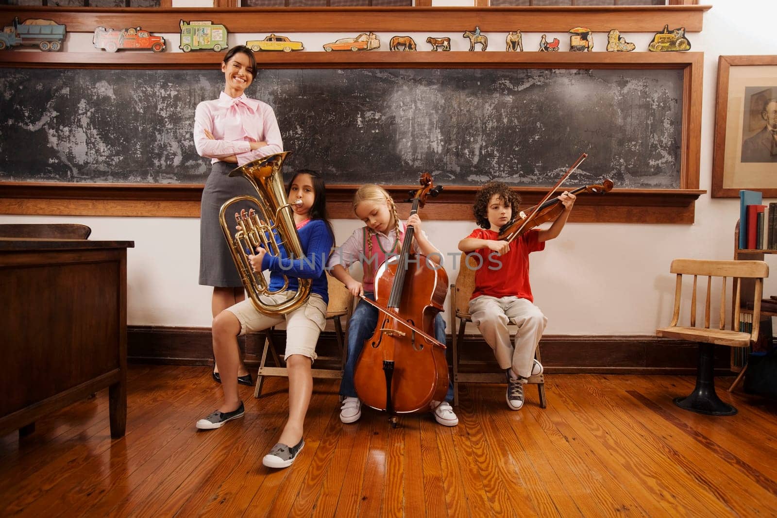 Students playing musical instruments with their teacher standing beside them