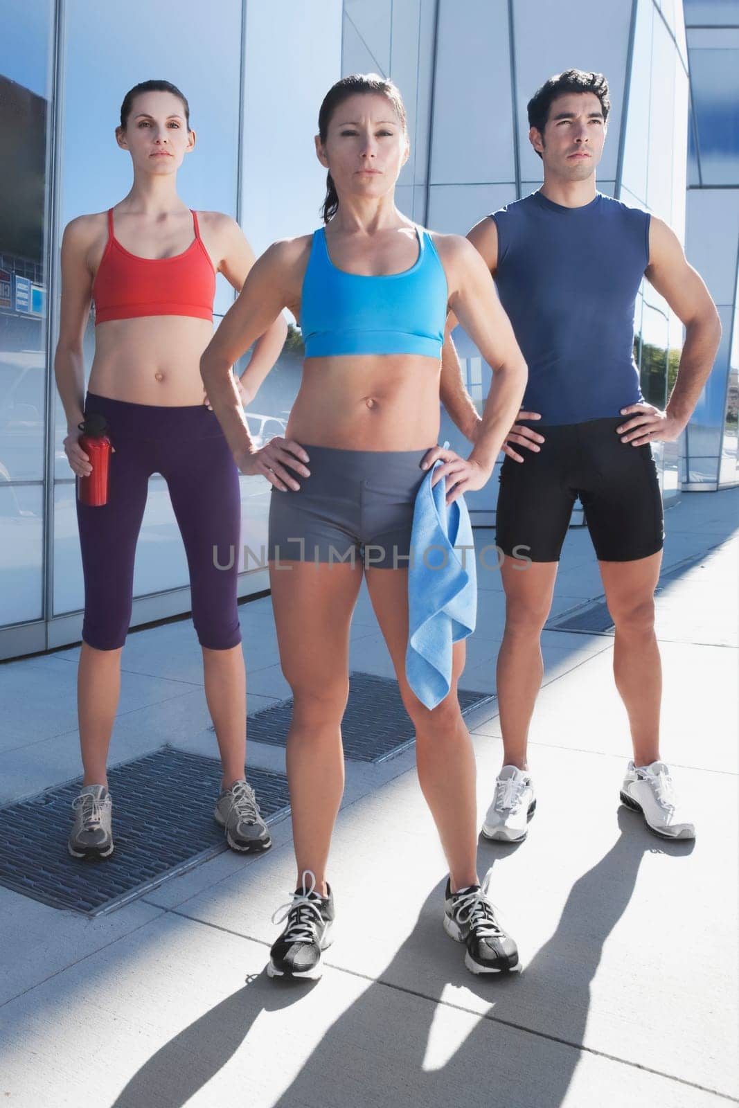 Man exercising with two women in front of a building