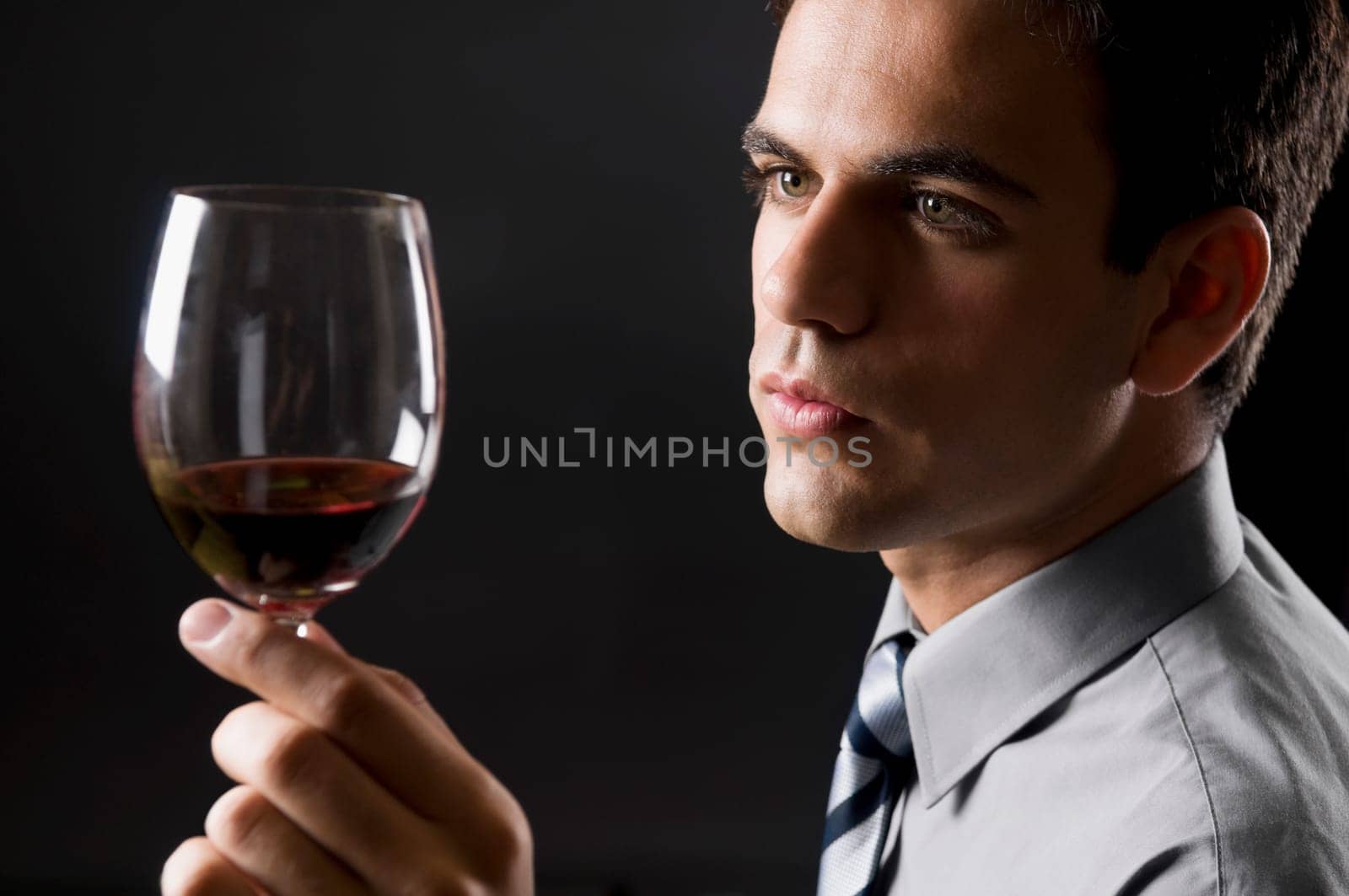 Businessman examining a glass of red wine