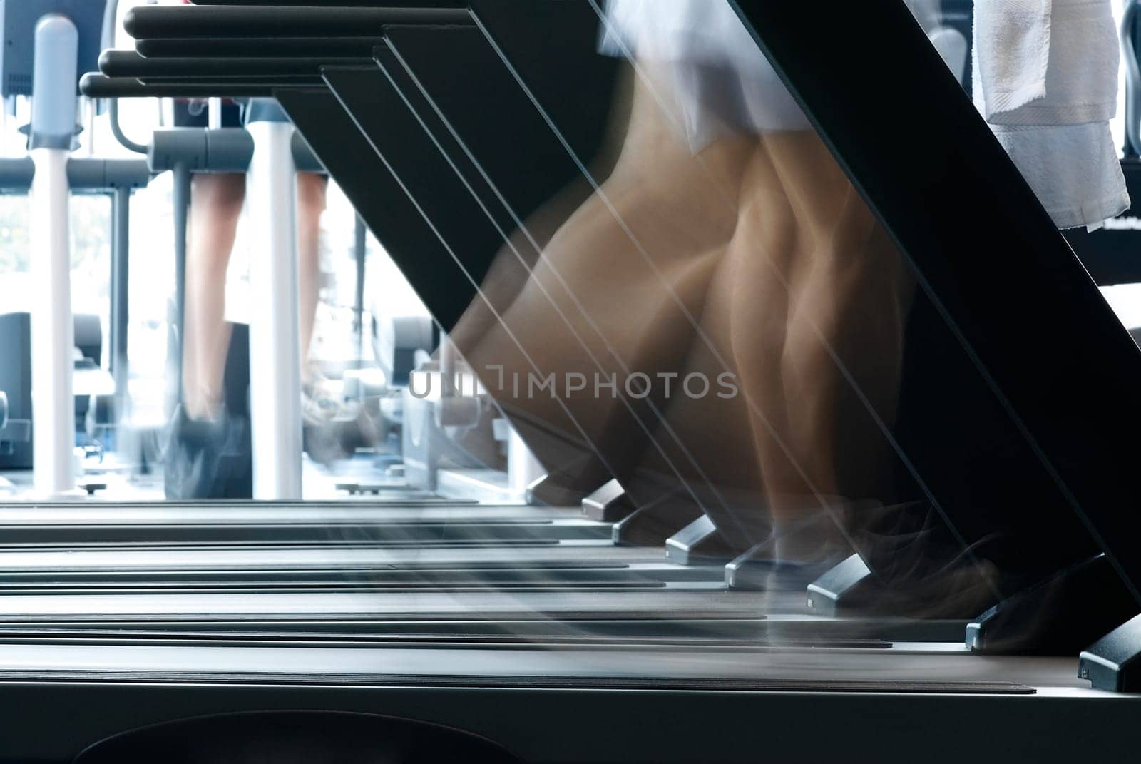 Person exercising on a treadmill machine in a gym