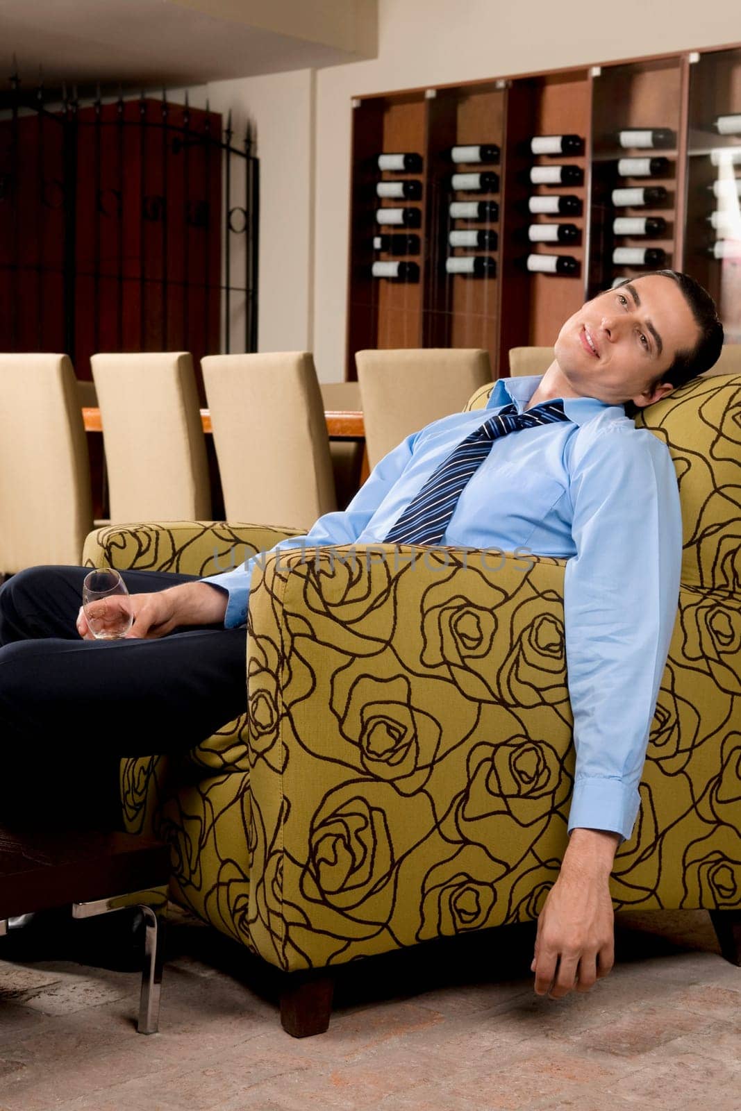 Drunk businessman sitting in an armchair