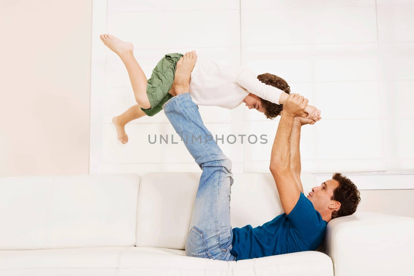 Man playing with his son on a couch