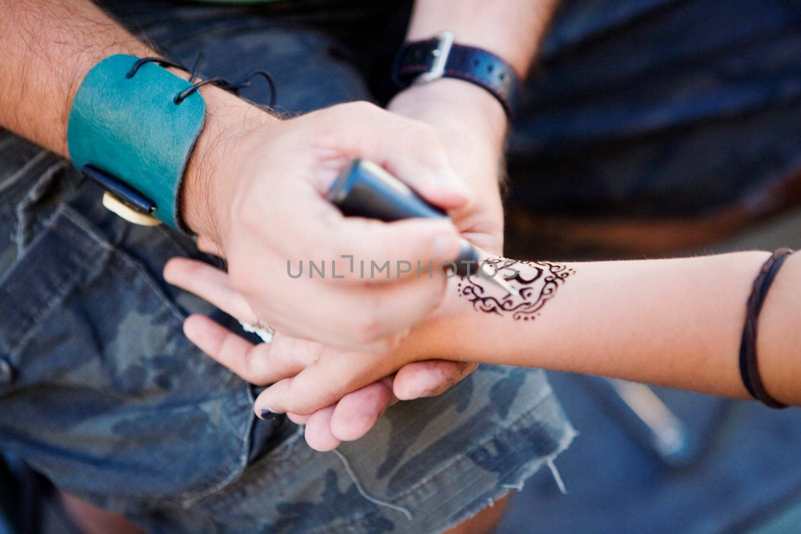 High angle view of a personŽs hand drawing a tattoo on a hand