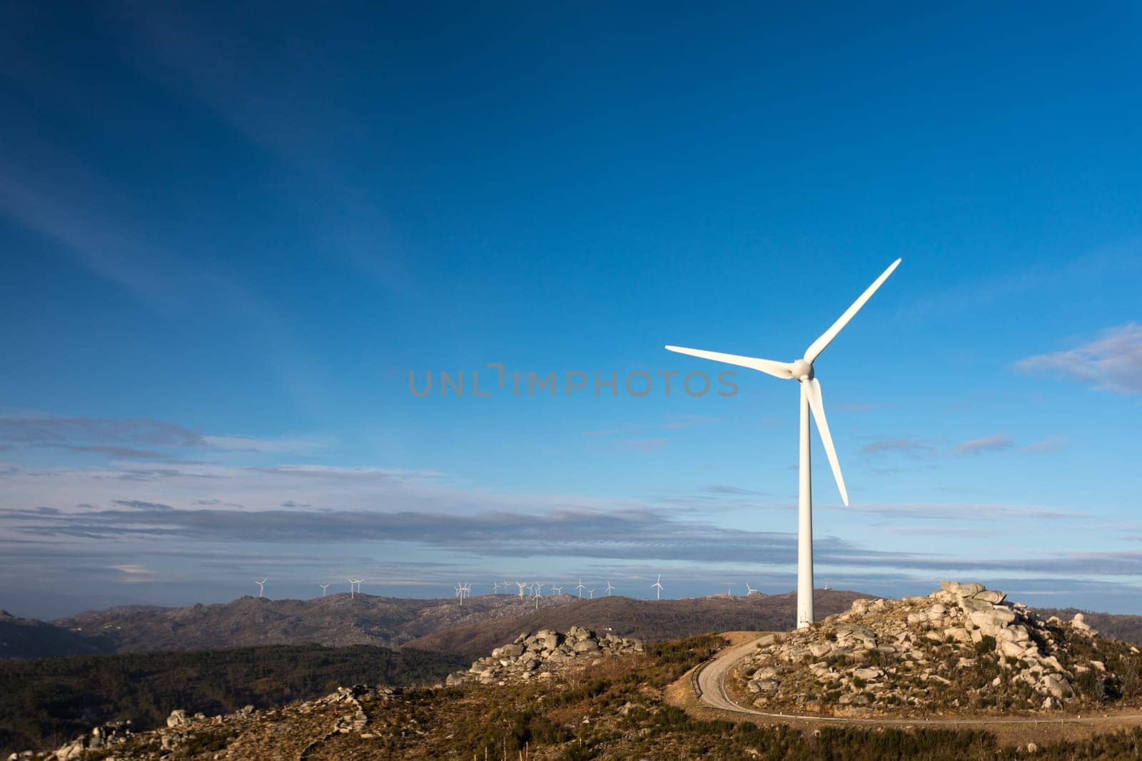 Wind energy turbines, in a landscpae over a beautiful blue sky