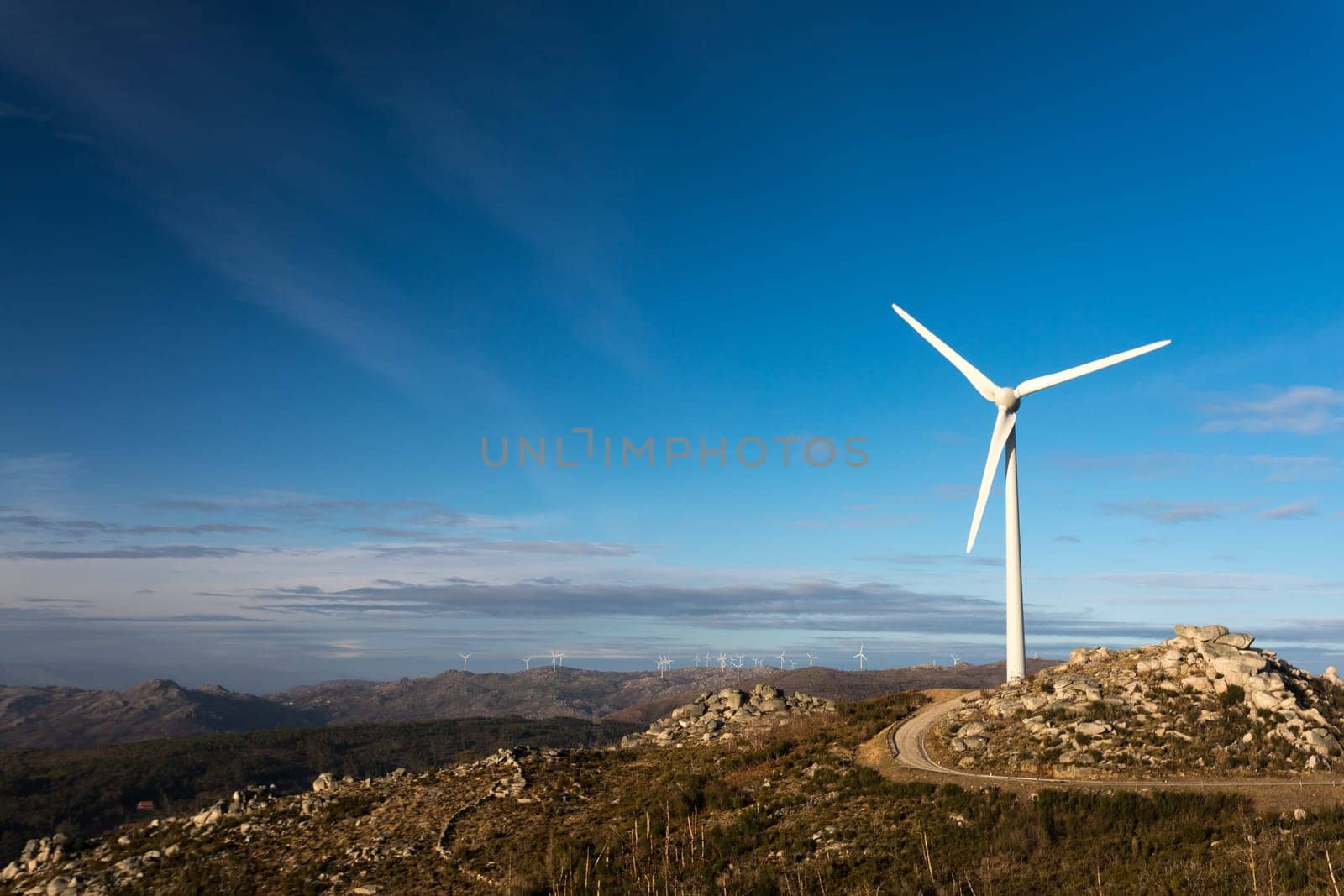 Wind energy turbines, in a landscpae over a beautiful blue sky