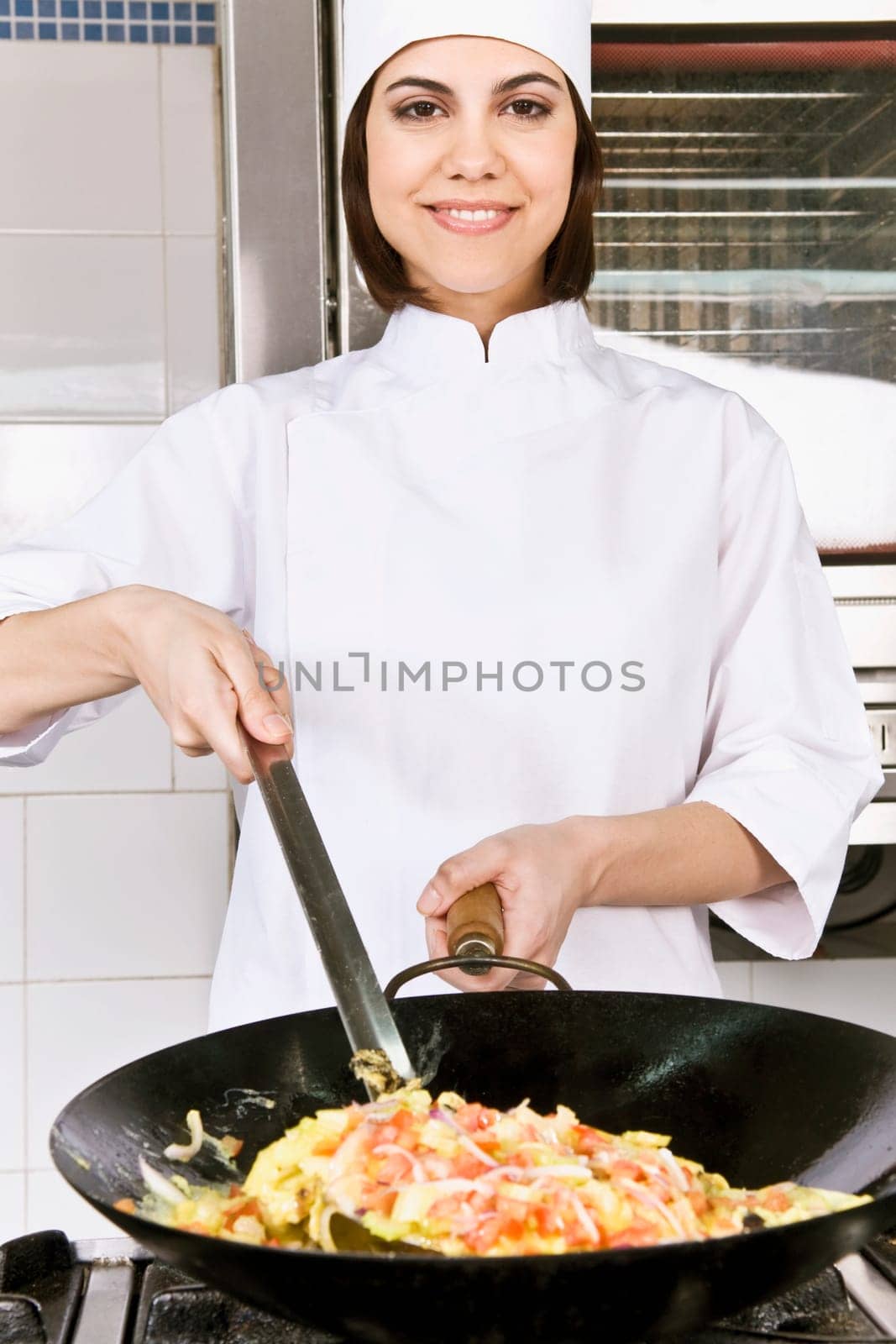 Female chef cooking food in the kitchen