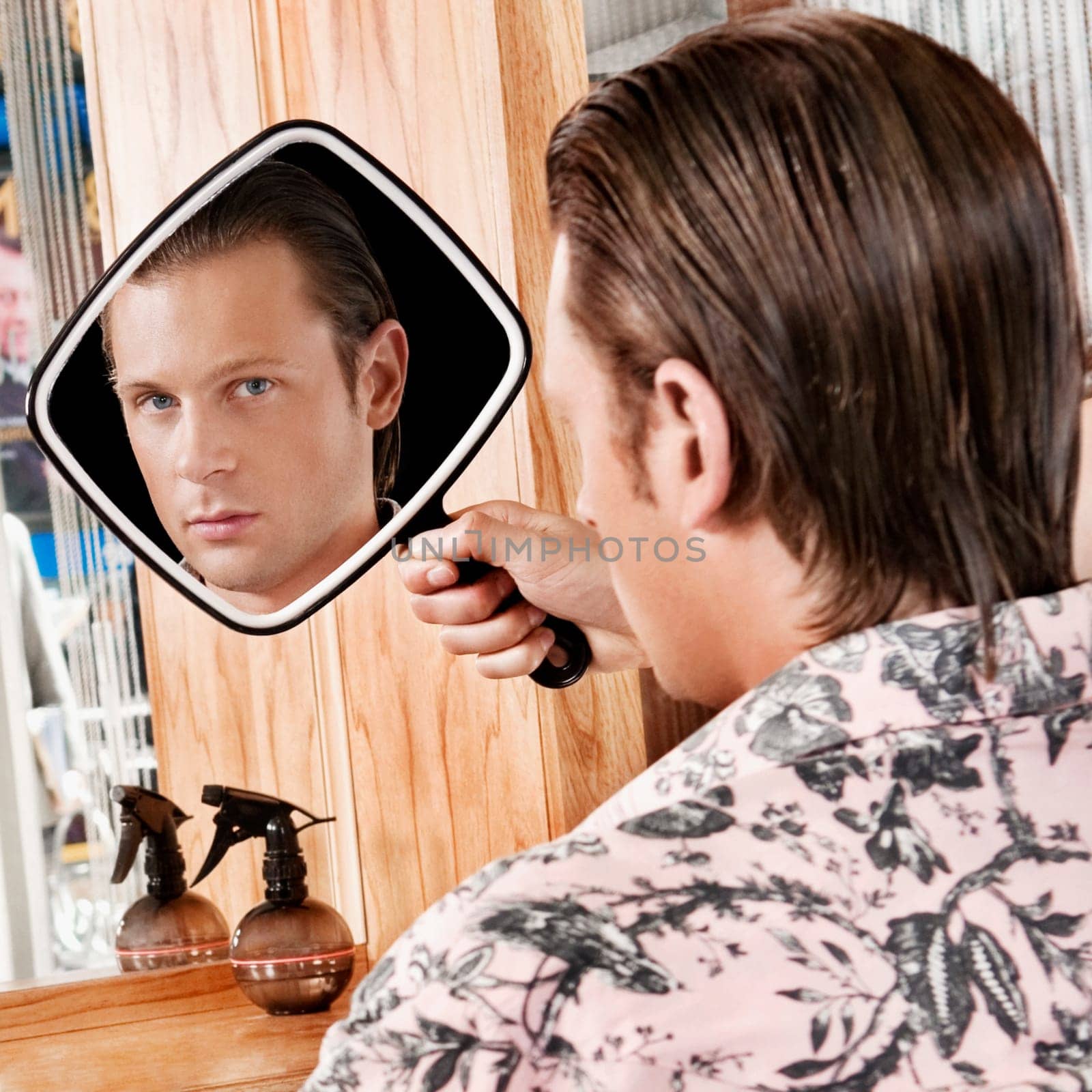 Man looking himself in a mirror after a haircut