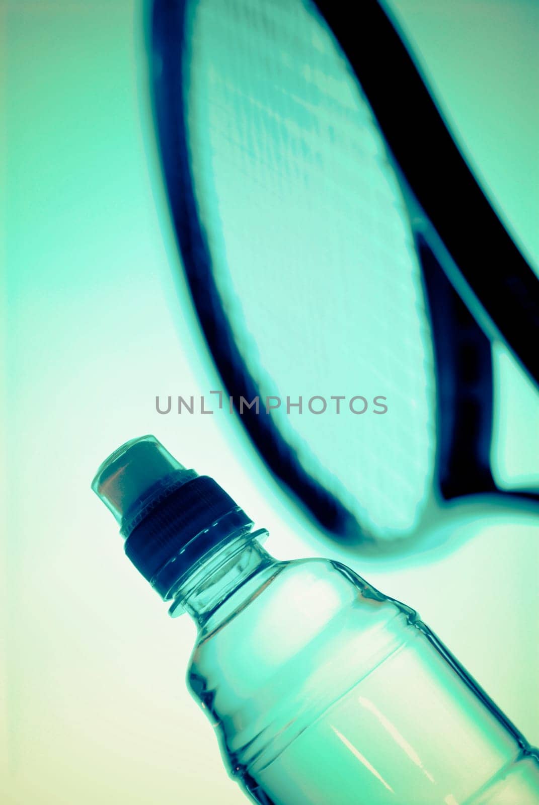Close_up of a water bottle and a tennis racket