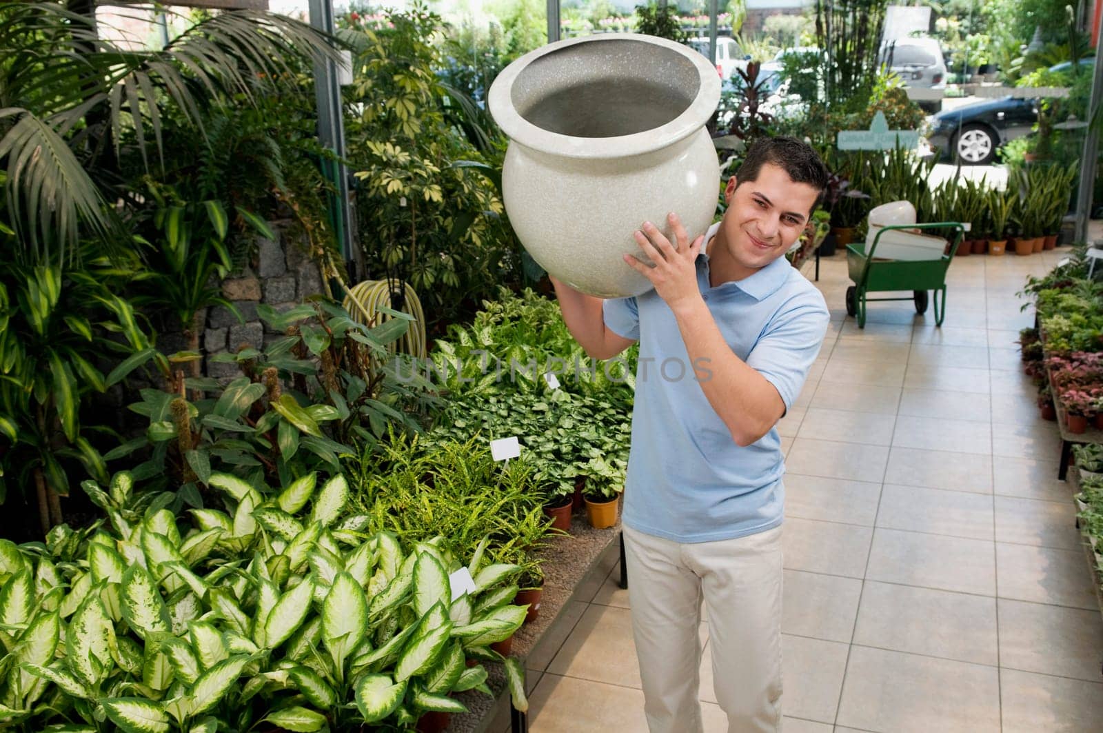 Customer holding a decorative urn in a greenhouse