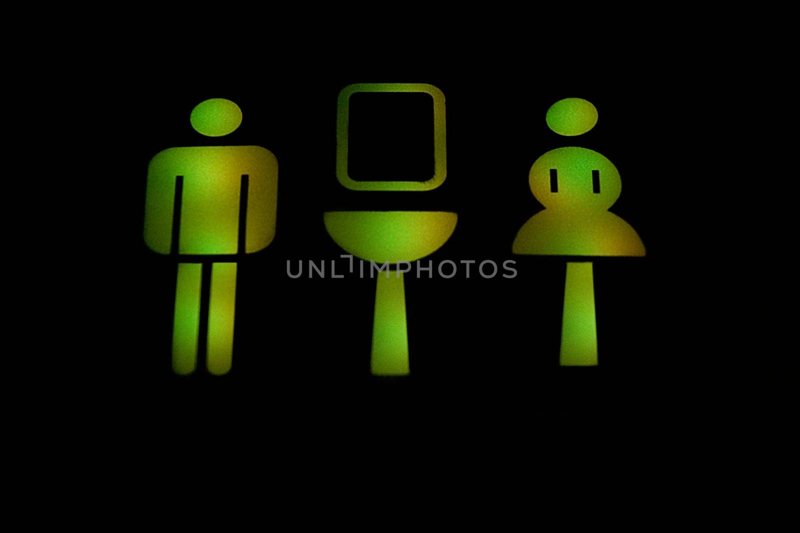 Close_up of illuminated male and female toilet signs in an airplane