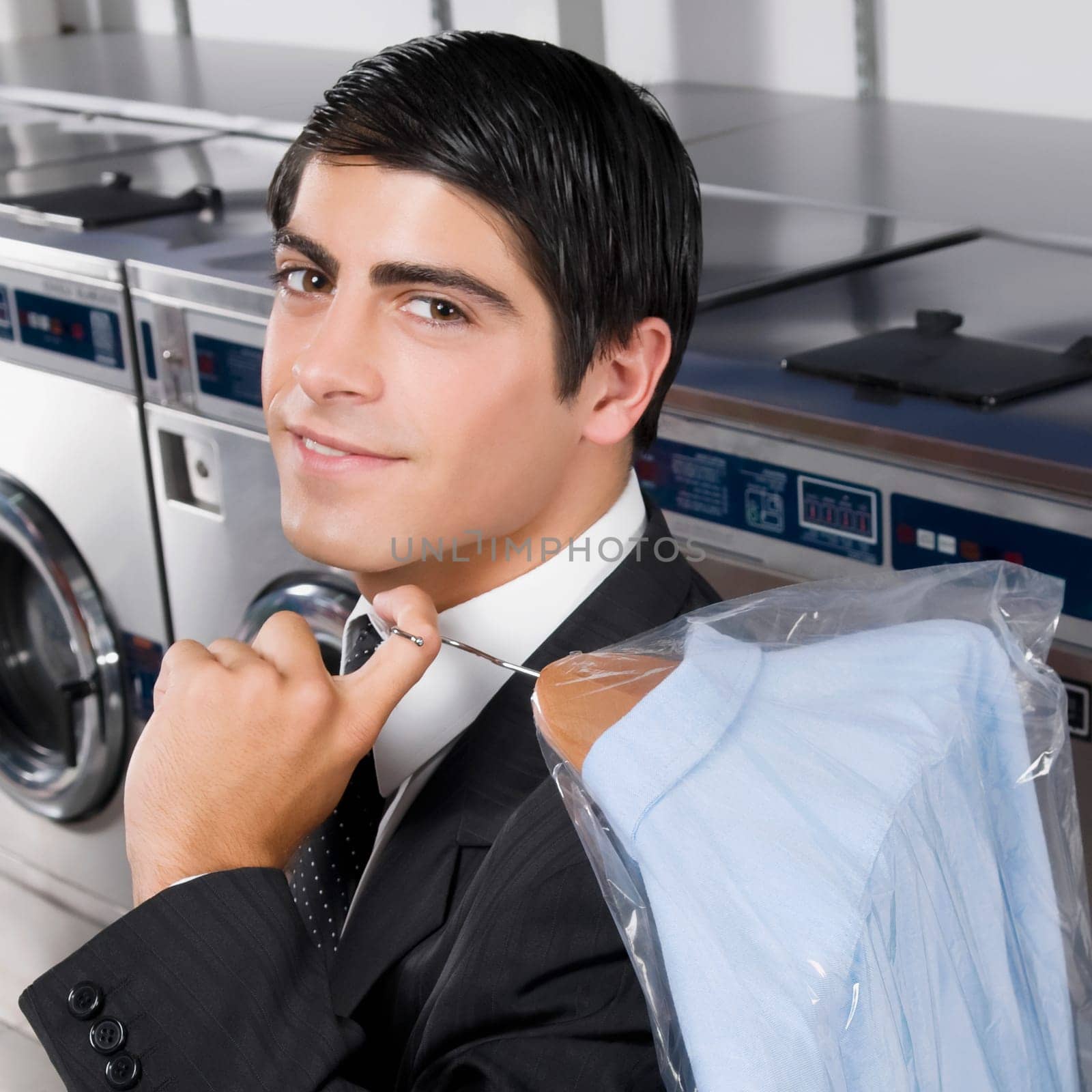 Businessman carrying a hanger in a laundromat