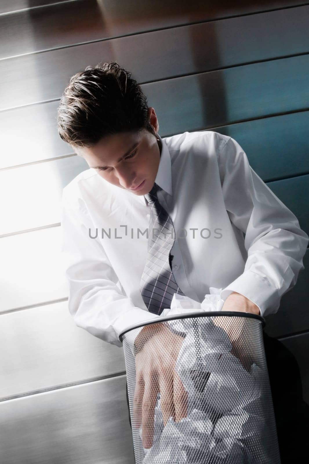 Businessman searching in a wastepaper basket