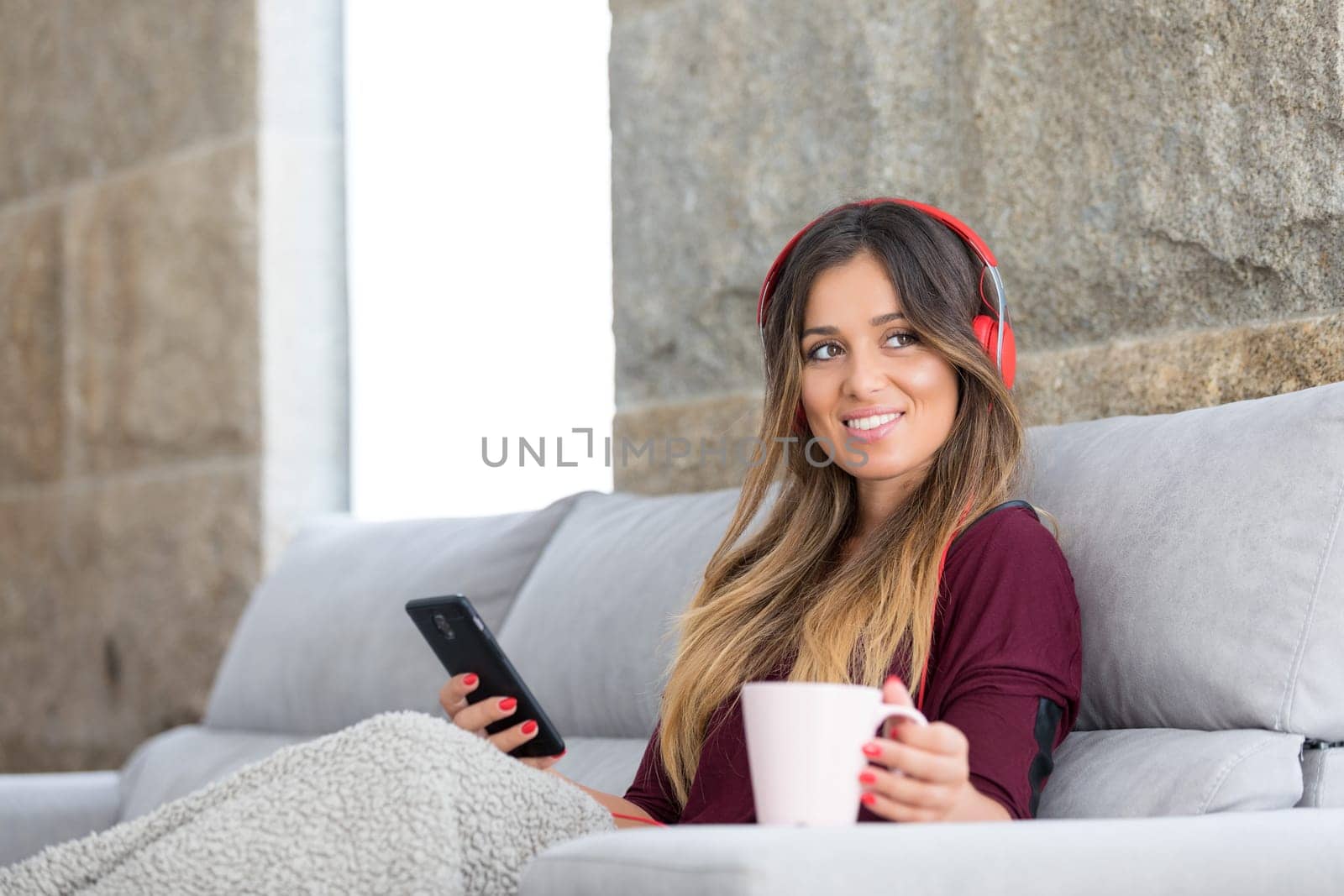 Beautiful young woman relaxing on couch while listening to some music