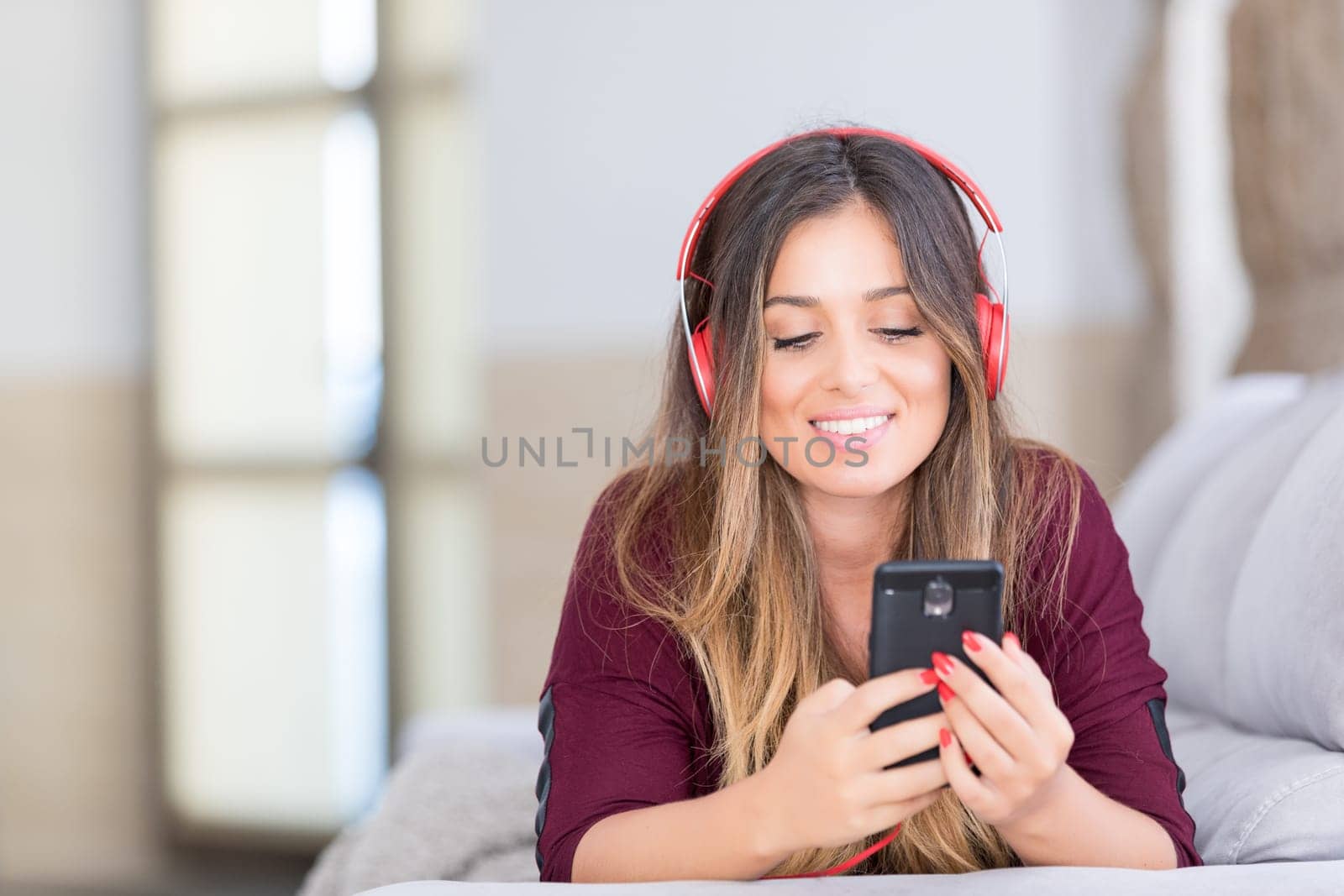 Beautiful young woman relaxing on couch while listening to some music