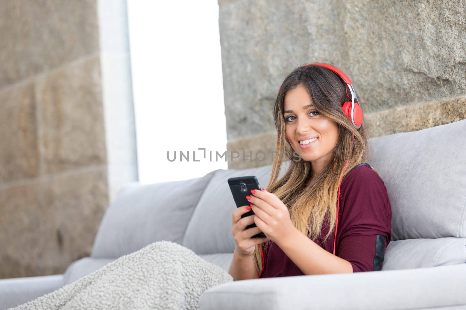 Beautiful young woman relaxing on couch while listening to some music