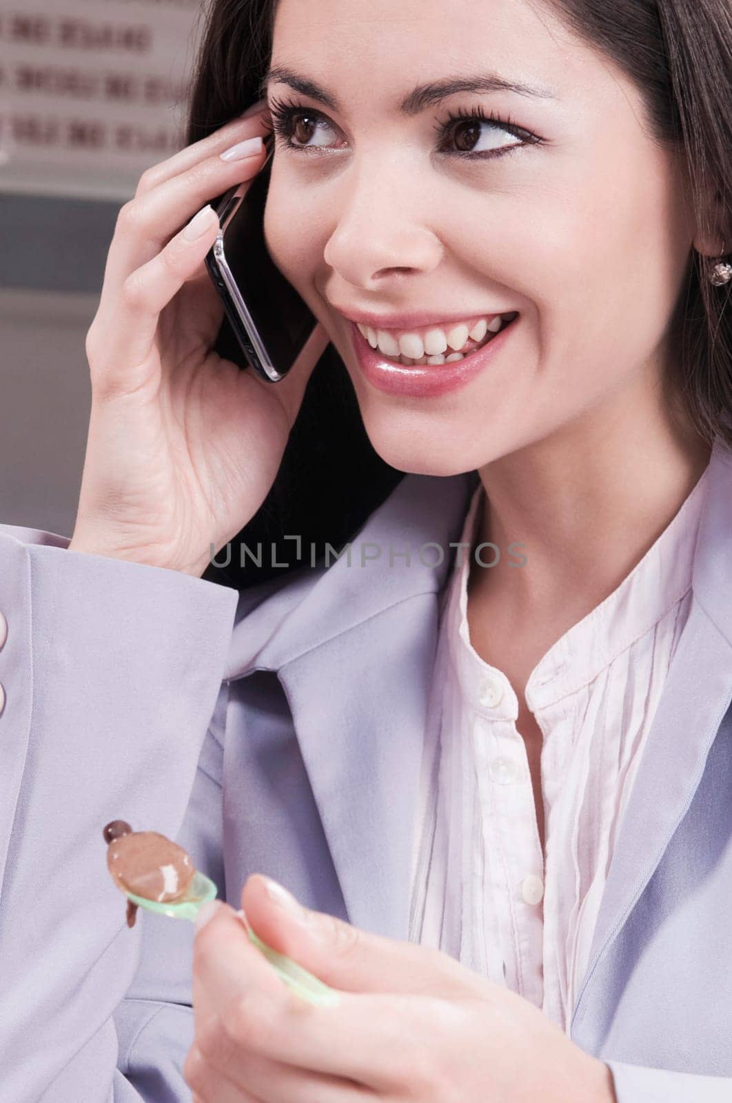 Woman eating ice cream and talking on a mobile phone