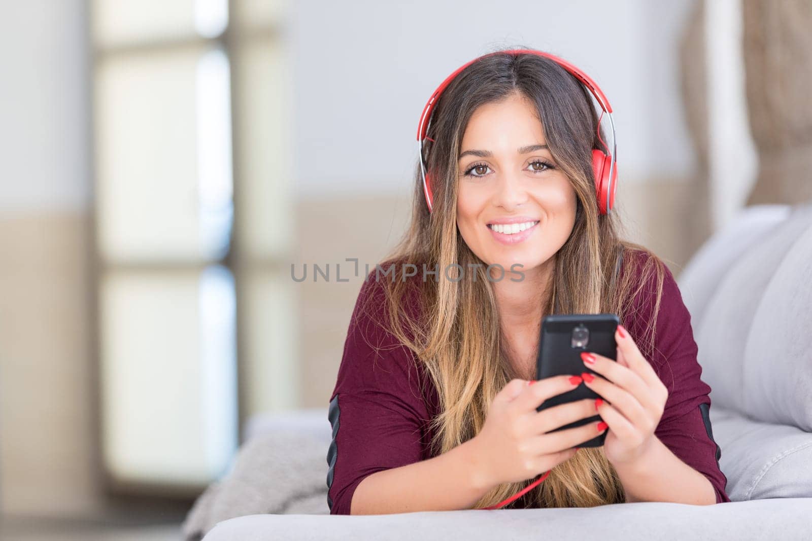 Beautiful young woman relaxing on couch while listening to some music