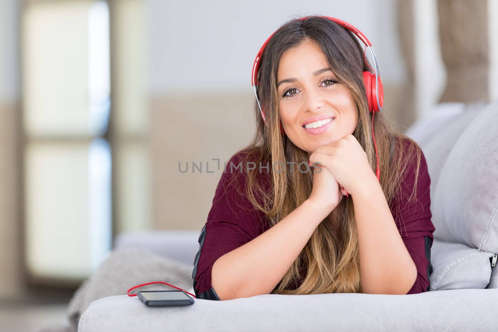 Beautiful young woman relaxing on couch while listening to some music