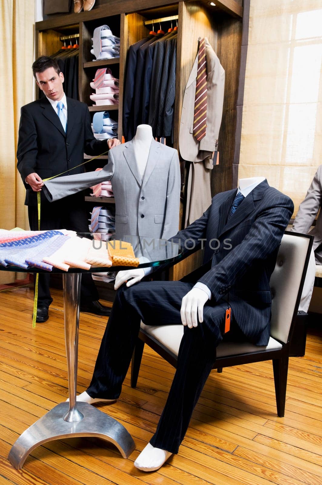Tailor taking measurement in a clothing store
