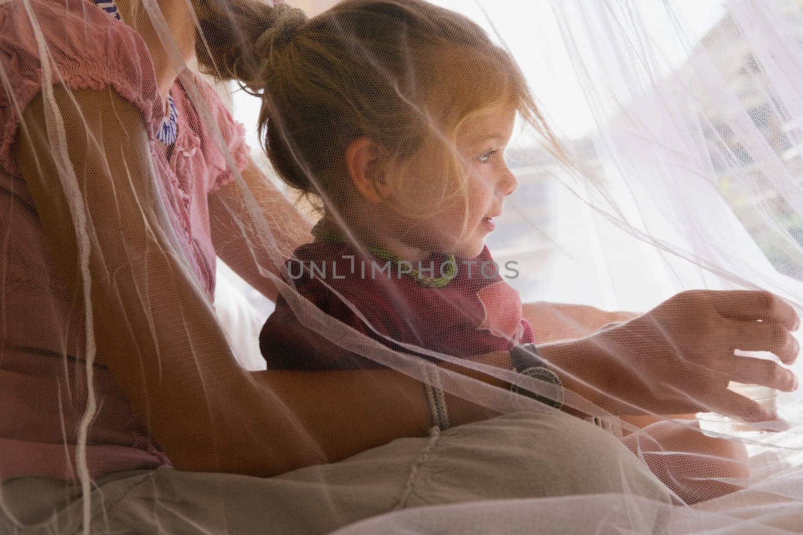 Baby girl sitting with her mother in the bedroom