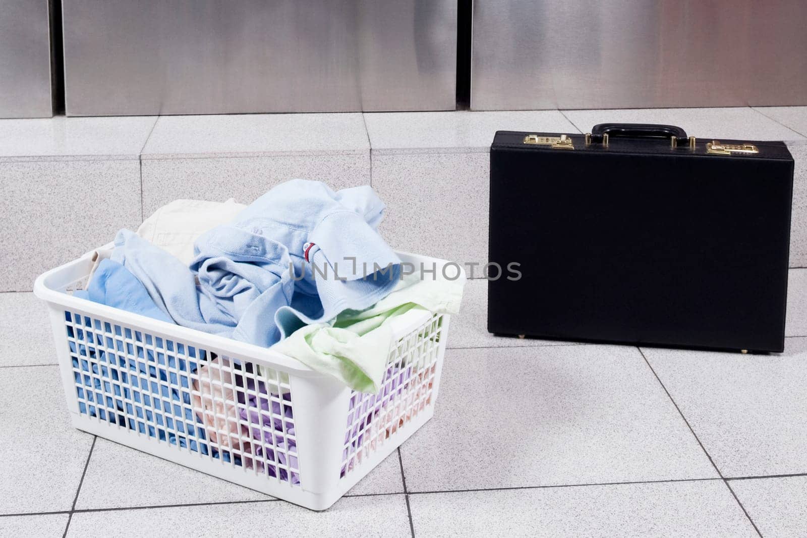 Laundry basket near a briefcase in a laundromat