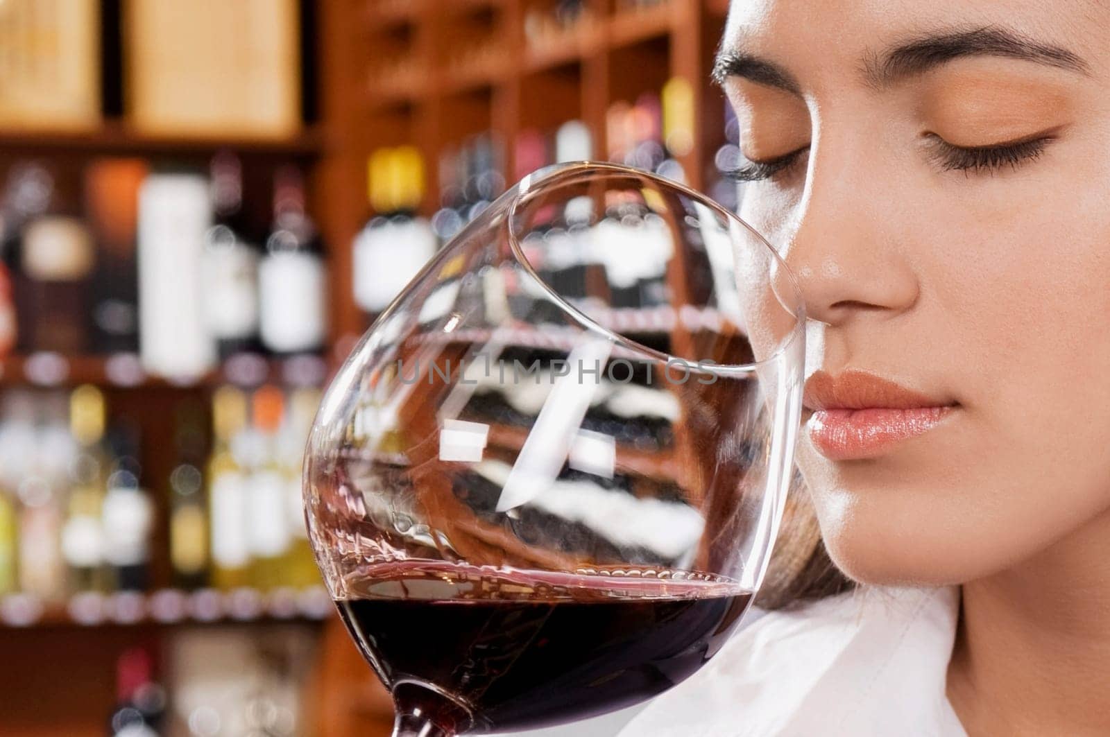 Businesswoman smelling a glass of red wine