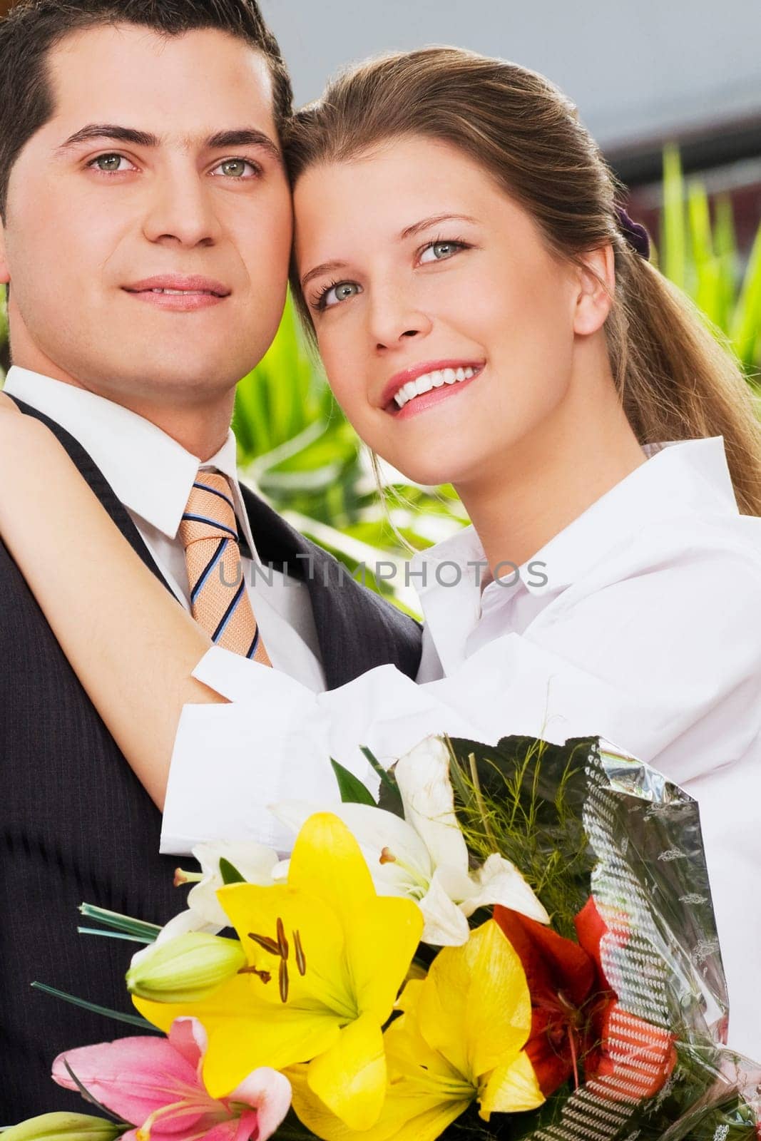 Man holding a bouquet of flowers with a woman smiling