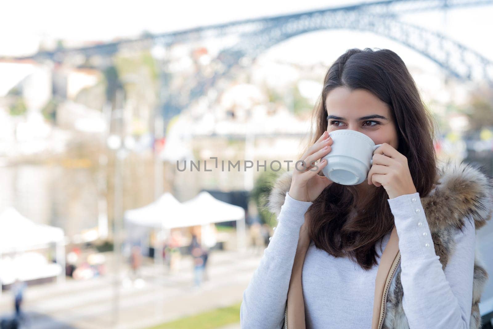 Woman relaxing at balcony enjoying sunrise. Good morning