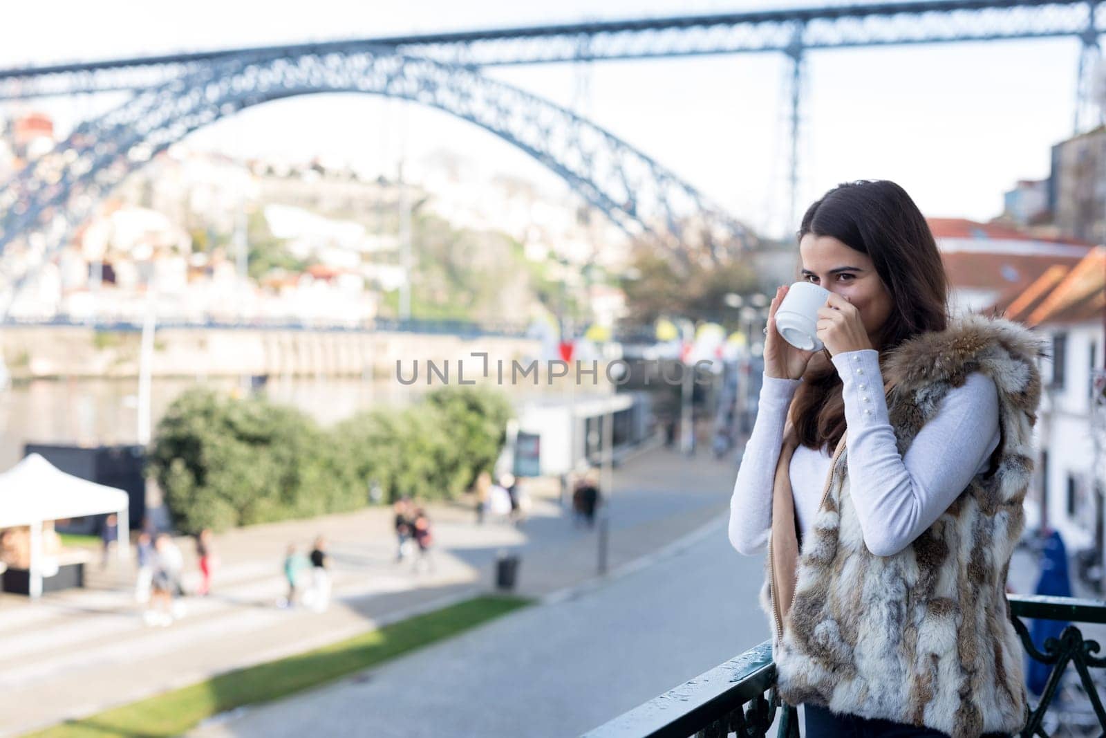Woman relaxing at balcony enjoying sunrise. Good morning