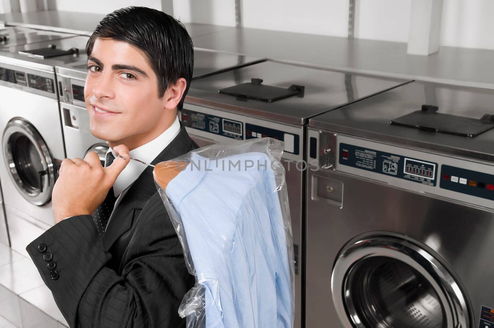 Businessman carrying a hanger in a laundromat