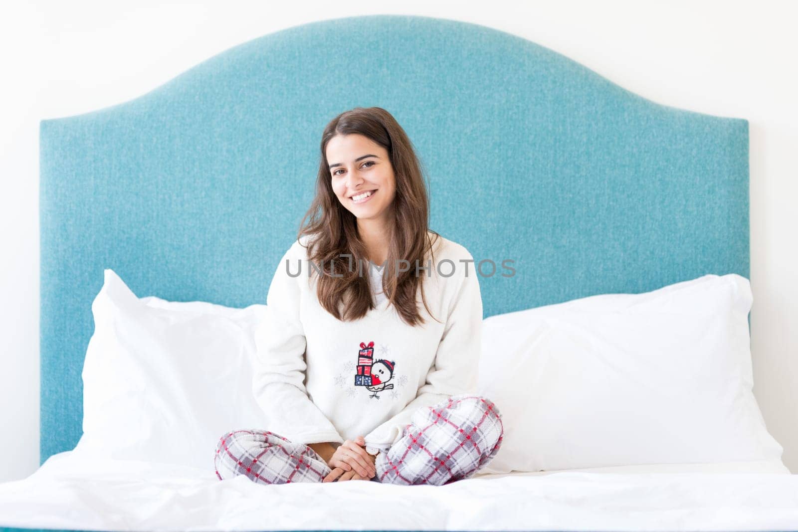 Beautiful happy young woman relaxing in bed