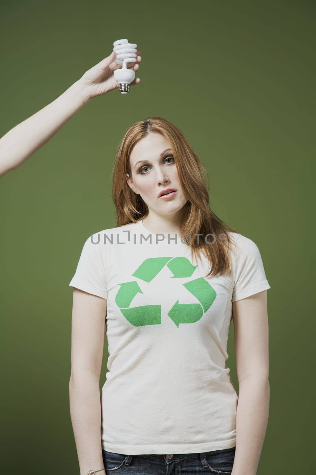 PersonŽs hand holding a light bulb above a womanŽs head