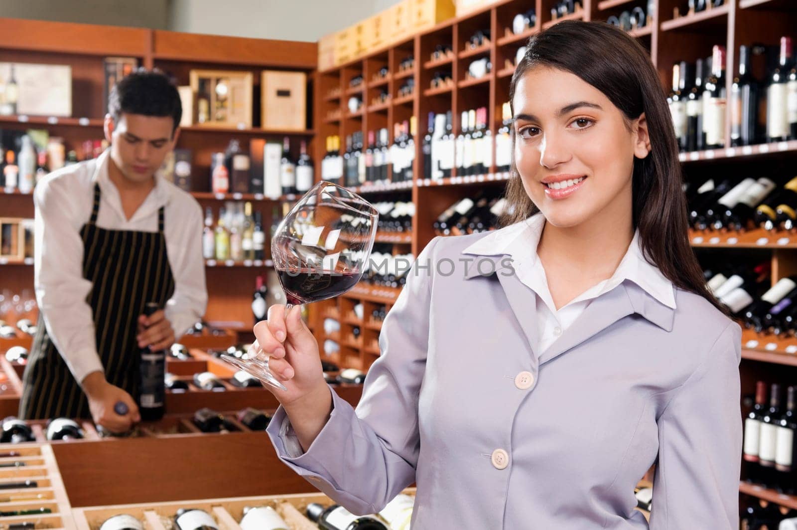 Businesswoman holding a glass of wine in a bar and smiling